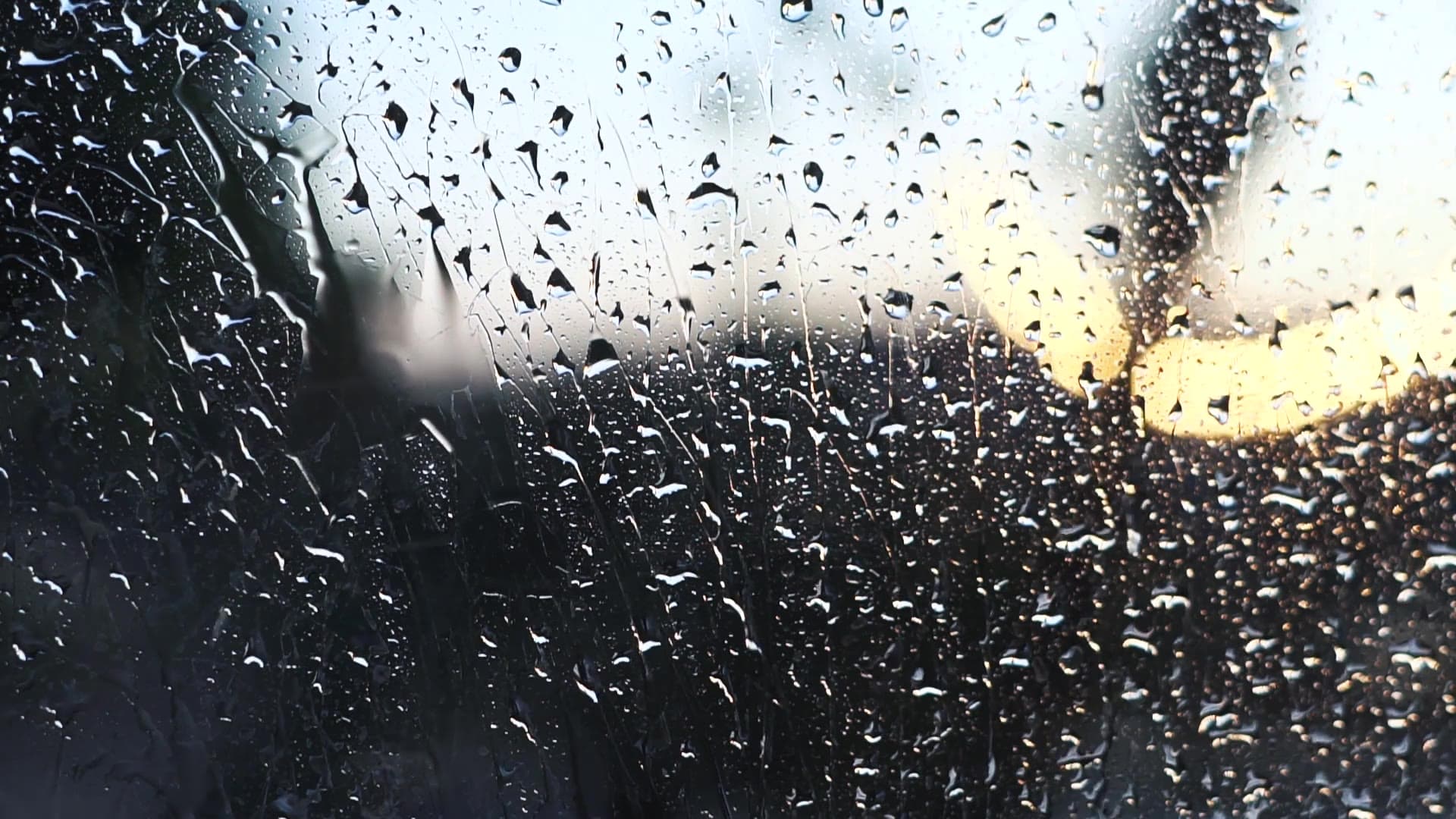 Raindrops on a window glowing in warm evening light